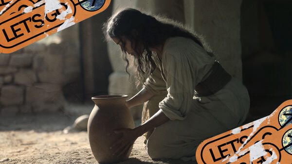 A young widow crouches down to pick up a jar of oil.
