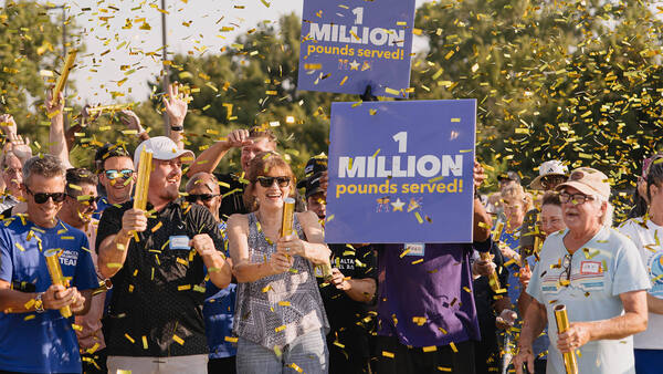 Gold confetti falls on Gateway Church volunteers as they celebrate one million pounds of food given away